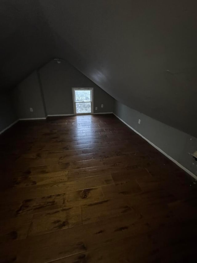 bonus room with lofted ceiling and dark hardwood / wood-style floors