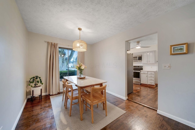 dining space featuring dark hardwood / wood-style floors and a textured ceiling