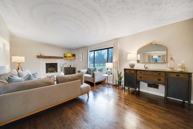 living room featuring dark hardwood / wood-style flooring, a fireplace, and a textured ceiling