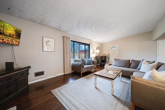 living room with dark hardwood / wood-style flooring and a textured ceiling