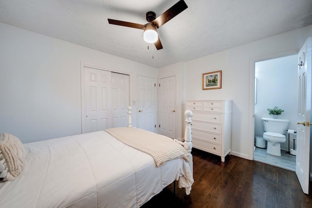 bedroom with dark hardwood / wood-style flooring, multiple closets, and ceiling fan