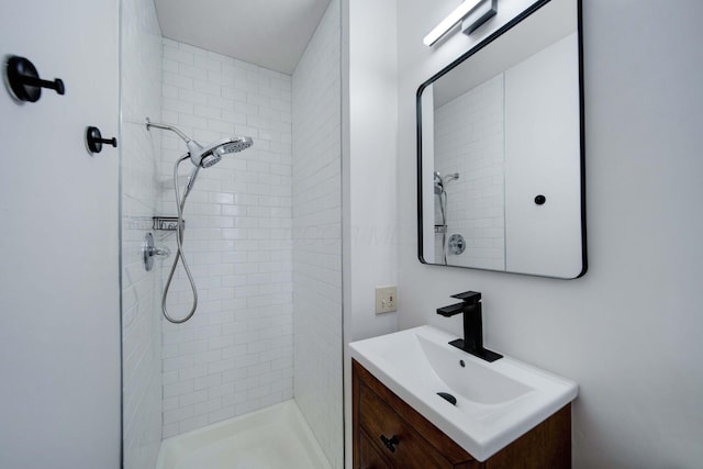 bathroom with vanity and a tile shower