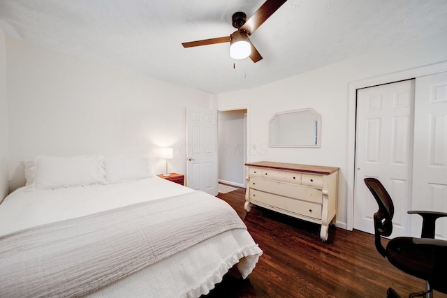 bedroom with dark wood-type flooring, ceiling fan, and a closet