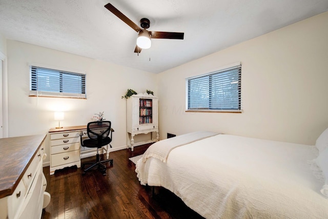 bedroom featuring multiple windows, a textured ceiling, dark hardwood / wood-style floors, and ceiling fan