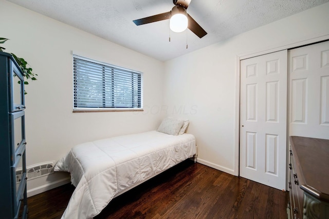 bedroom with ceiling fan, dark wood-type flooring, a closet, and a textured ceiling