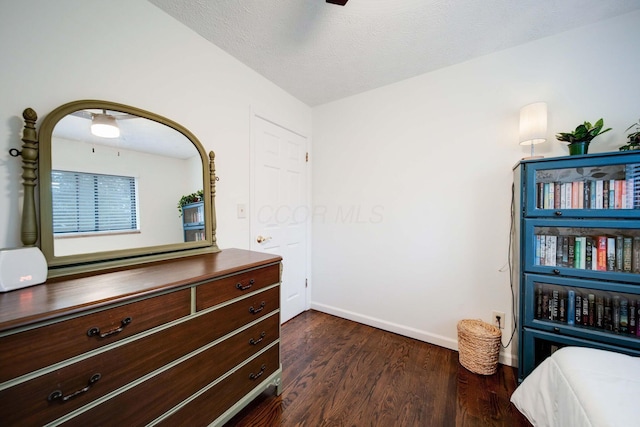 bedroom featuring a textured ceiling and dark hardwood / wood-style flooring