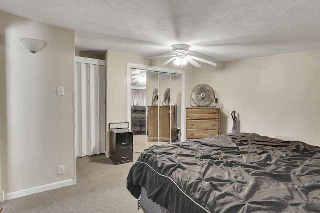 carpeted bedroom featuring a textured ceiling, a ceiling fan, and baseboards