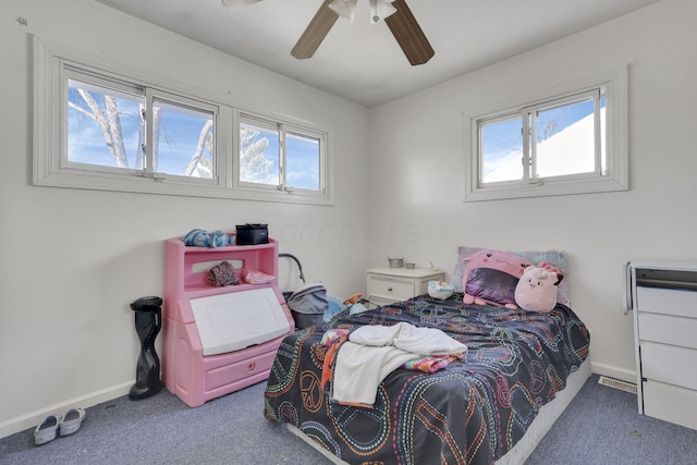 carpeted bedroom featuring ceiling fan, multiple windows, and baseboards