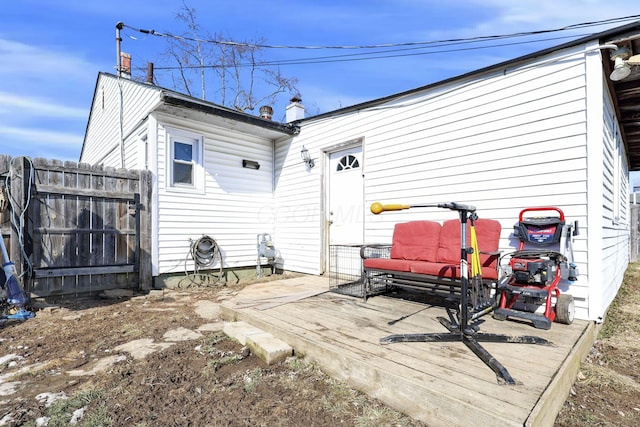 back of house featuring fence and a wooden deck