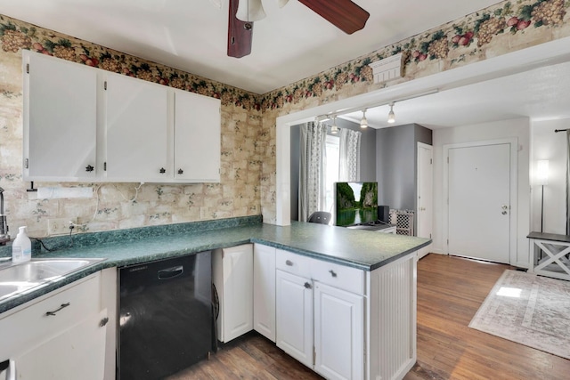 kitchen featuring dark countertops, white cabinetry, dishwasher, and a peninsula