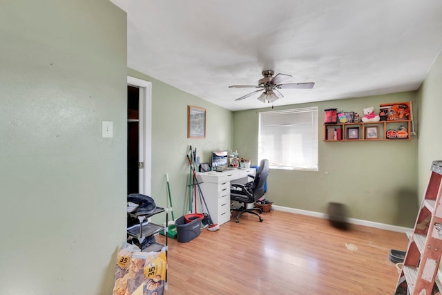 office featuring a ceiling fan, baseboards, and light wood finished floors