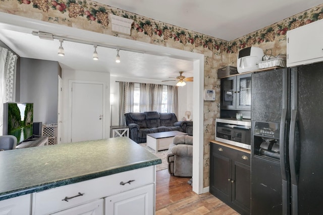 kitchen with dark countertops, white cabinets, and black refrigerator with ice dispenser