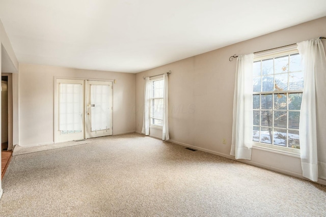 carpeted spare room with french doors