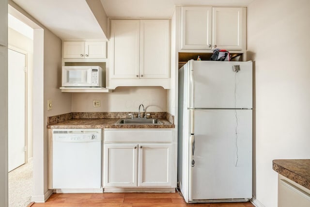 kitchen with white cabinetry, sink, white appliances, and light hardwood / wood-style flooring