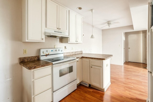 kitchen with electric stove, kitchen peninsula, hanging light fixtures, and white cabinets