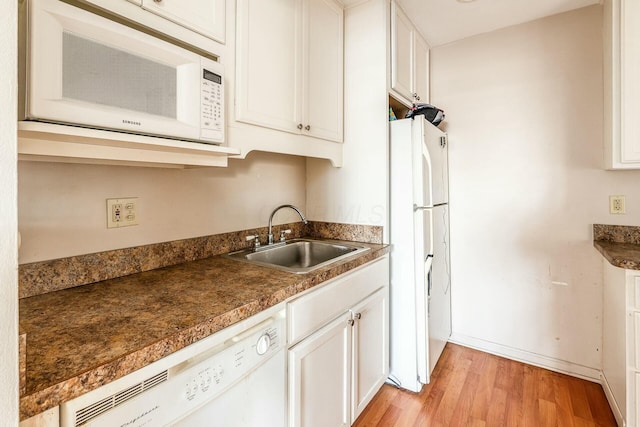 kitchen with white cabinetry, sink, white appliances, and light wood-type flooring