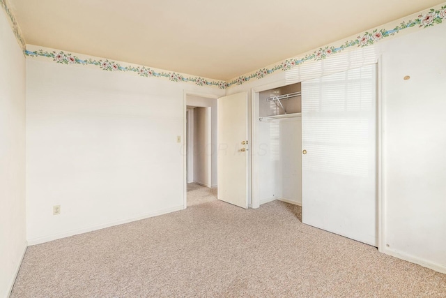 unfurnished bedroom with light carpet and a closet