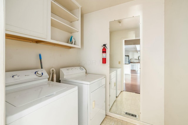 laundry room featuring cabinets and independent washer and dryer