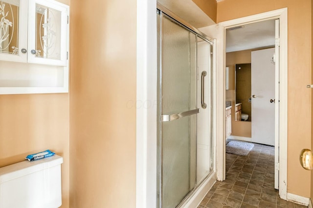 bathroom with vanity, toilet, and a shower with shower door