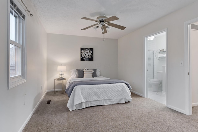 carpeted bedroom featuring connected bathroom, a textured ceiling, and ceiling fan