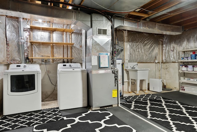 laundry area with washer and clothes dryer, sink, and heating unit