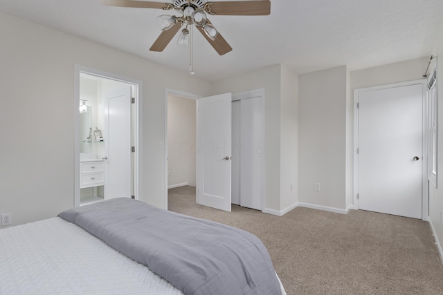 carpeted bedroom with ceiling fan, ensuite bathroom, and a closet