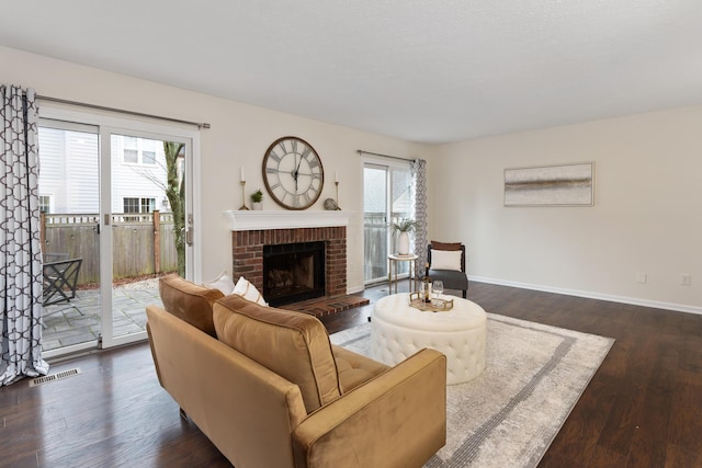 living room featuring dark hardwood / wood-style flooring and a brick fireplace