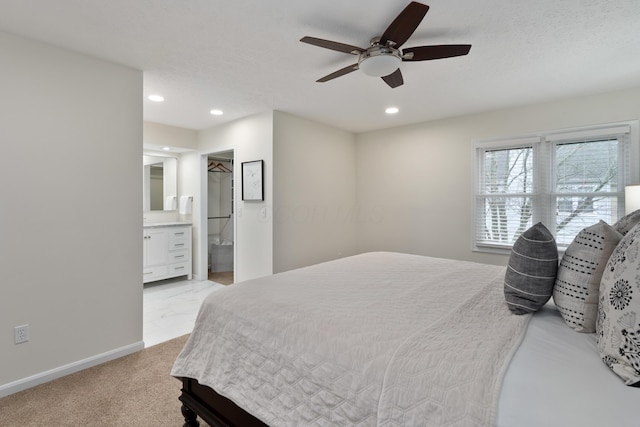 bedroom with ceiling fan, light colored carpet, a textured ceiling, and ensuite bathroom