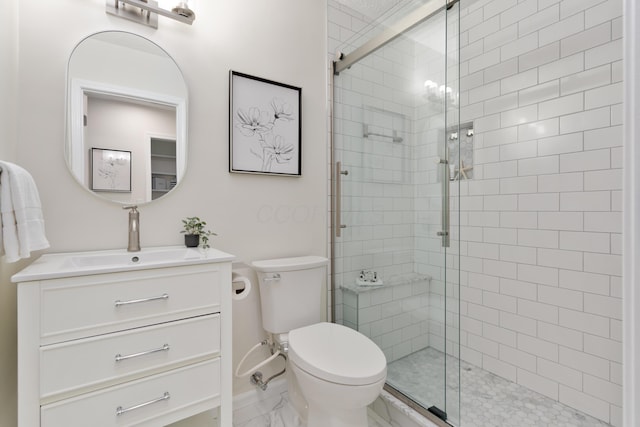 bathroom with vanity, a shower with shower door, and toilet