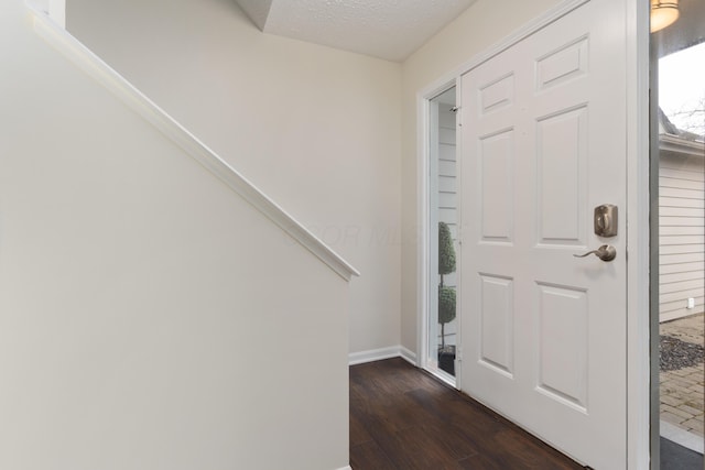 foyer with dark hardwood / wood-style flooring and a textured ceiling