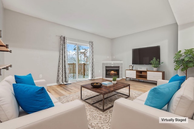 living room featuring a fireplace and light wood-type flooring