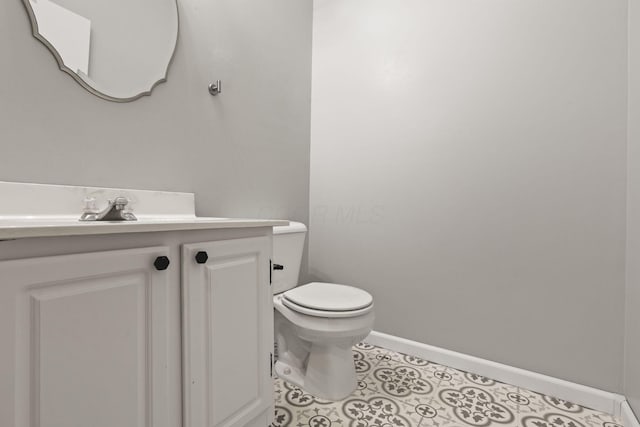 bathroom featuring tile patterned flooring, vanity, and toilet