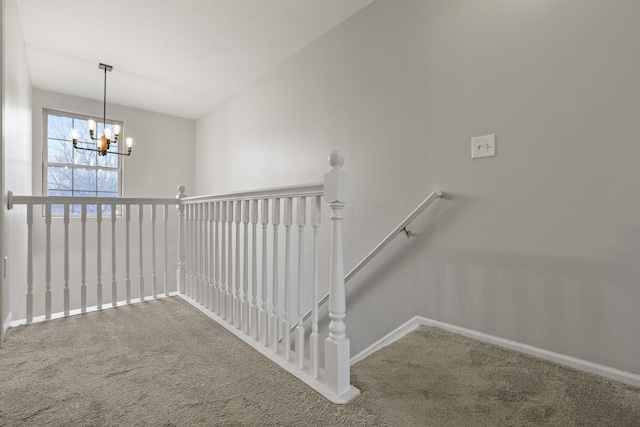 stairs featuring a notable chandelier and carpet flooring