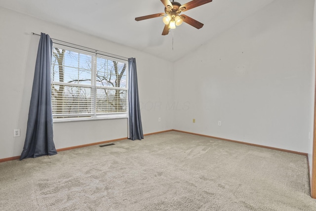 carpeted spare room with ceiling fan and vaulted ceiling