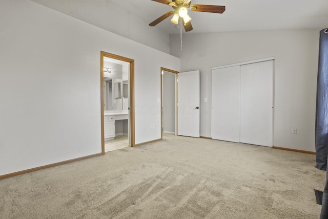 unfurnished bedroom with lofted ceiling, ensuite bathroom, light carpet, a closet, and ceiling fan