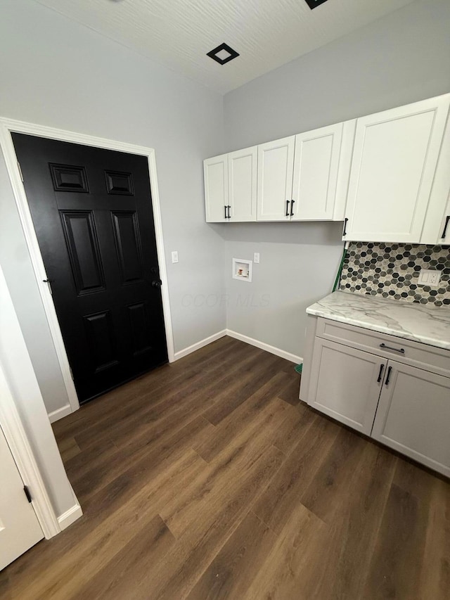 laundry room with hookup for a washing machine, baseboards, dark wood-style floors, and cabinet space