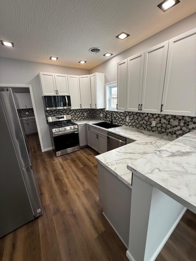 kitchen featuring stainless steel appliances, white cabinets, a sink, and visible vents