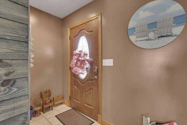 foyer featuring baseboards and light tile patterned flooring