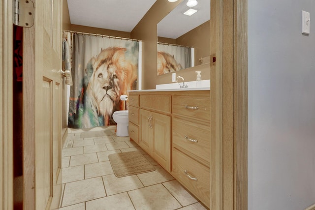 bathroom featuring toilet, tile patterned flooring, and vanity