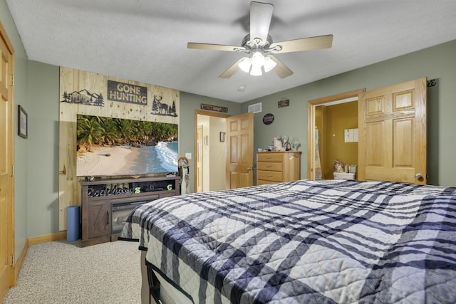 carpeted bedroom featuring a ceiling fan, baseboards, visible vents, and a textured ceiling