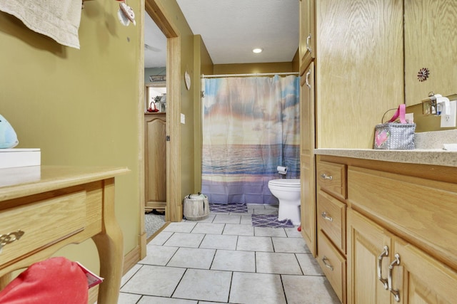 bathroom with vanity, a textured ceiling, toilet, and tile patterned floors