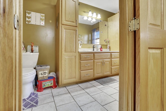 bathroom with toilet, vanity, and tile patterned floors