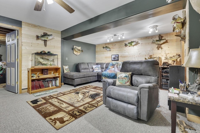 living room with carpet flooring, wood walls, beamed ceiling, and ceiling fan