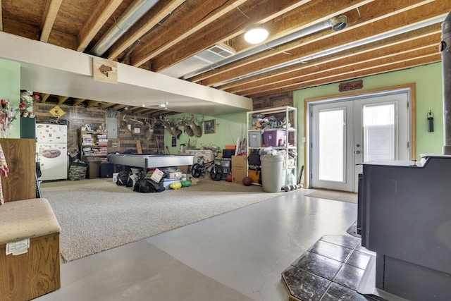 below grade area featuring french doors and freestanding refrigerator