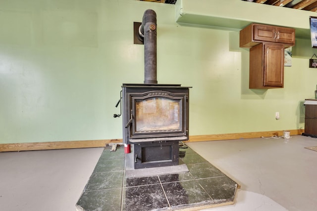 room details featuring a wood stove and baseboards