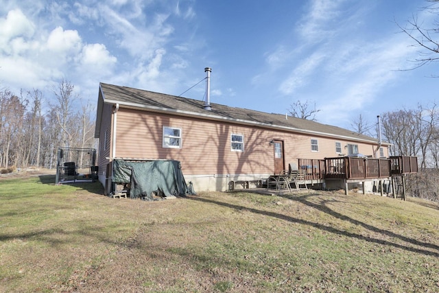 back of property with a deck and a lawn