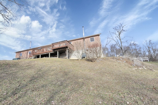 back of house with a deck and a yard