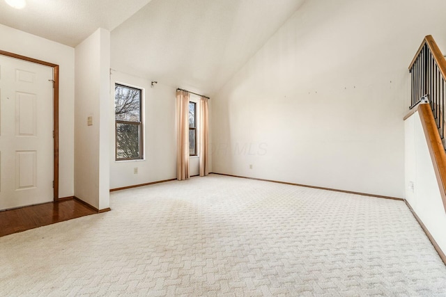 interior space featuring light carpet and high vaulted ceiling