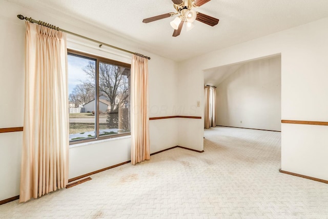 carpeted empty room featuring ceiling fan