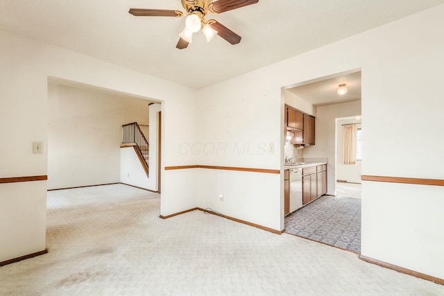 carpeted empty room with sink and ceiling fan